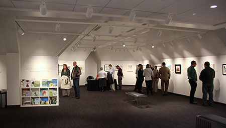 Several people enjoying artwork on the walls of The Gene Nelson Attic at the Provo Library