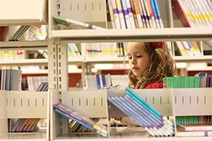 A girl browsing books that are on our booklists at Provo Library